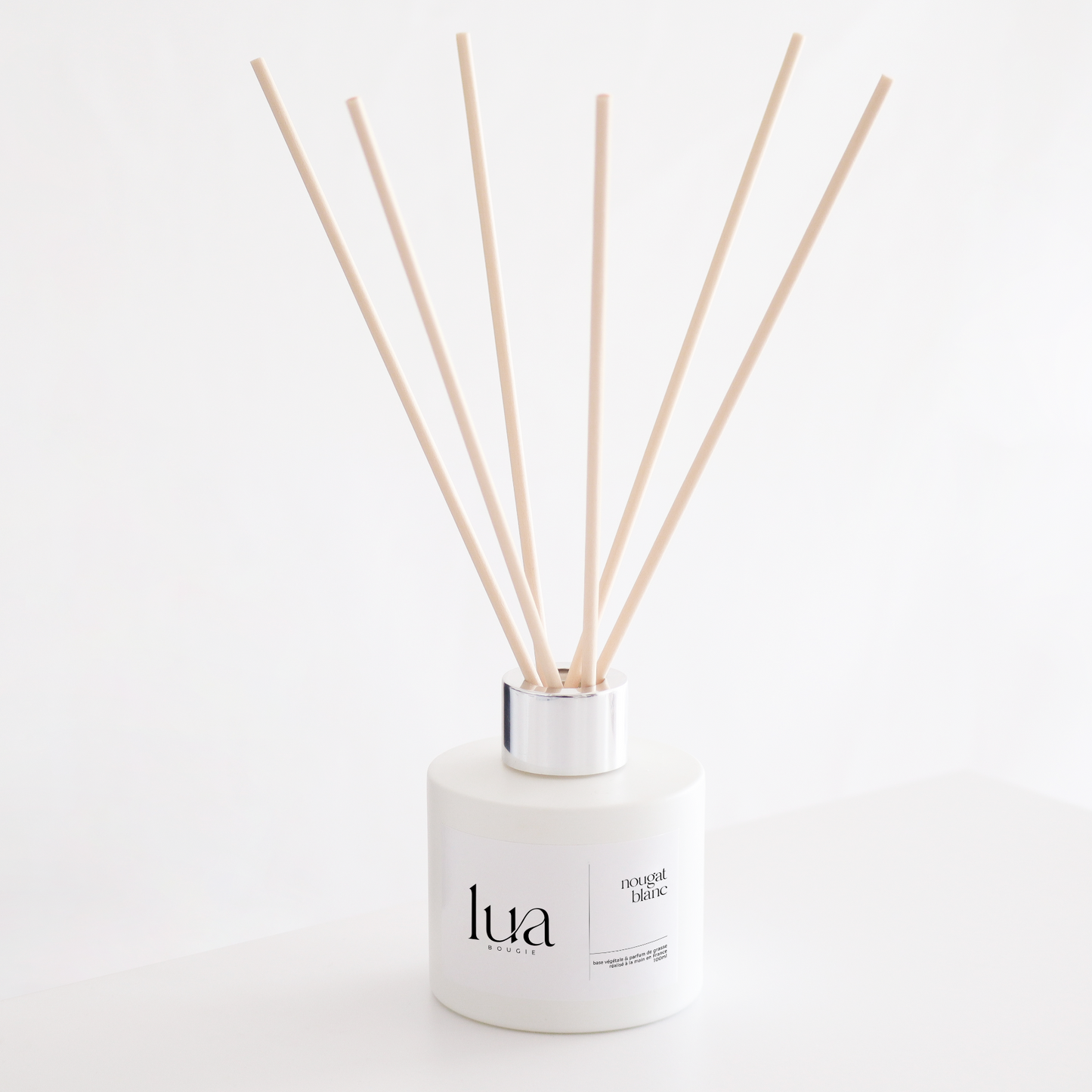 Diffuseur de parfum naturelle nougat blanc, couleur de contenant blanc et tige de rotin naturel. 