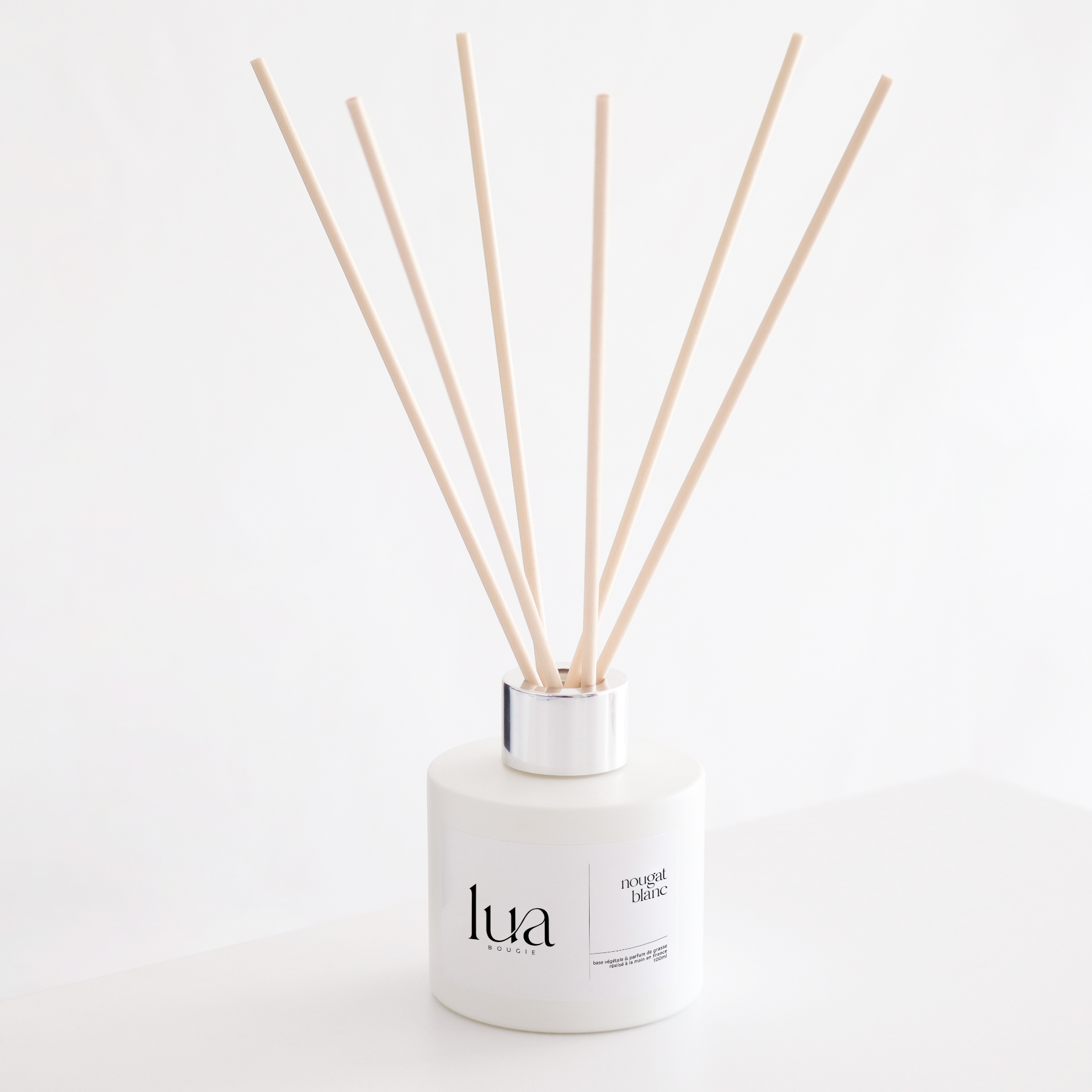 Diffuseur de parfum naturelle nougat blanc, couleur de contenant blanc et tige de rotin naturel. 